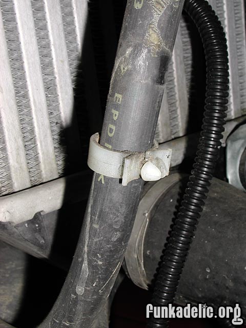 clip that holds the headlight washer hose in place on the reservoir